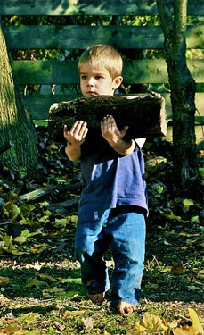 Young boy helps carry fire wood