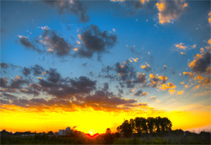 Sun setting at a factory